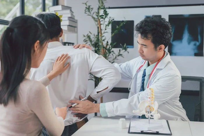 doctor checking patient's back