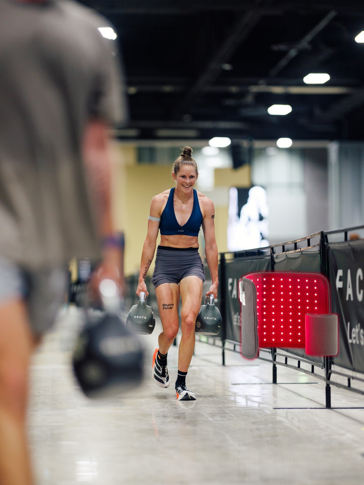 Runner's calves and quads mid-stride during a Hyrox run, right after finishing a heavy station